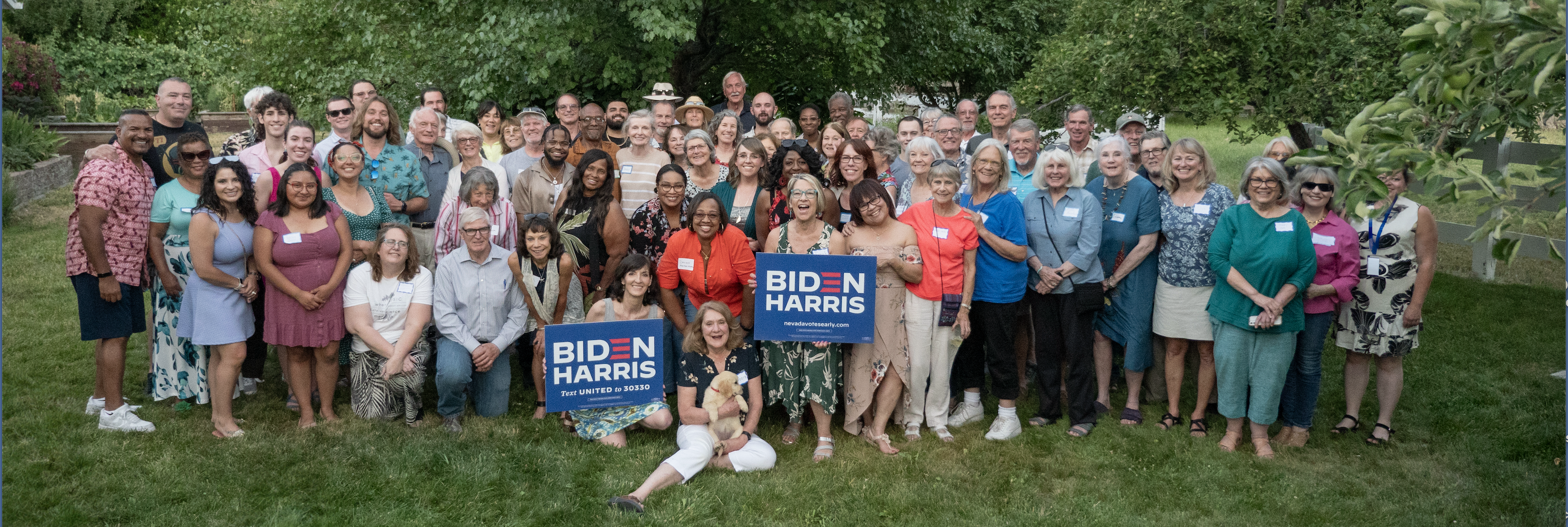 Group of people holding Biden signs in a backyard